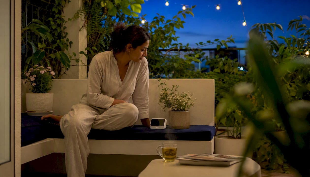 Woman checking bedroom air quality monitor