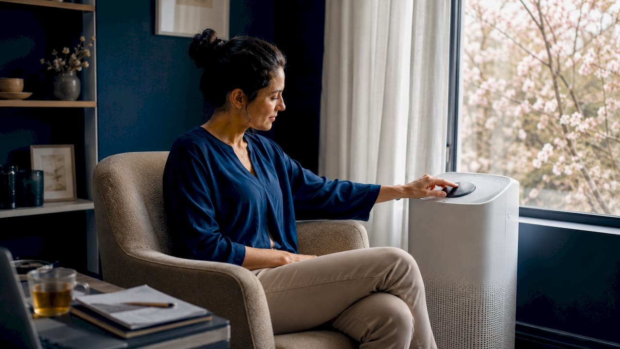 Woman adjusting air purifier in living room