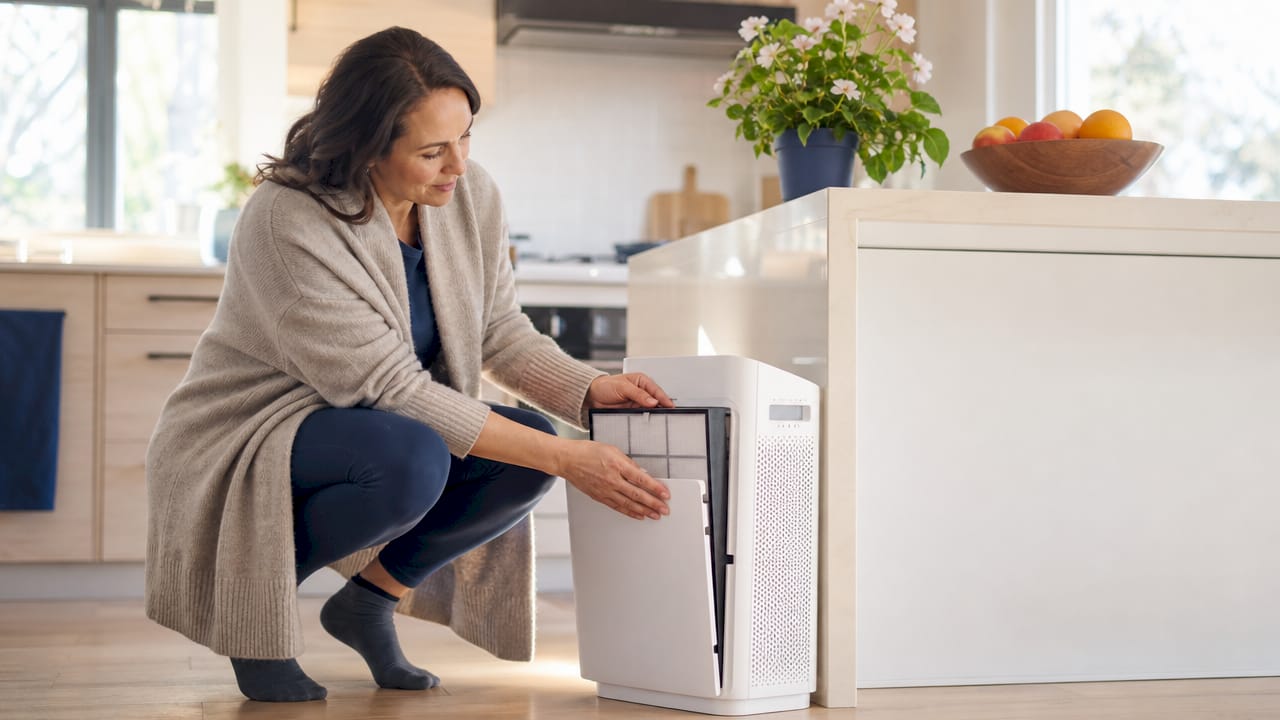Woman setting up HEPA air purifier at home
